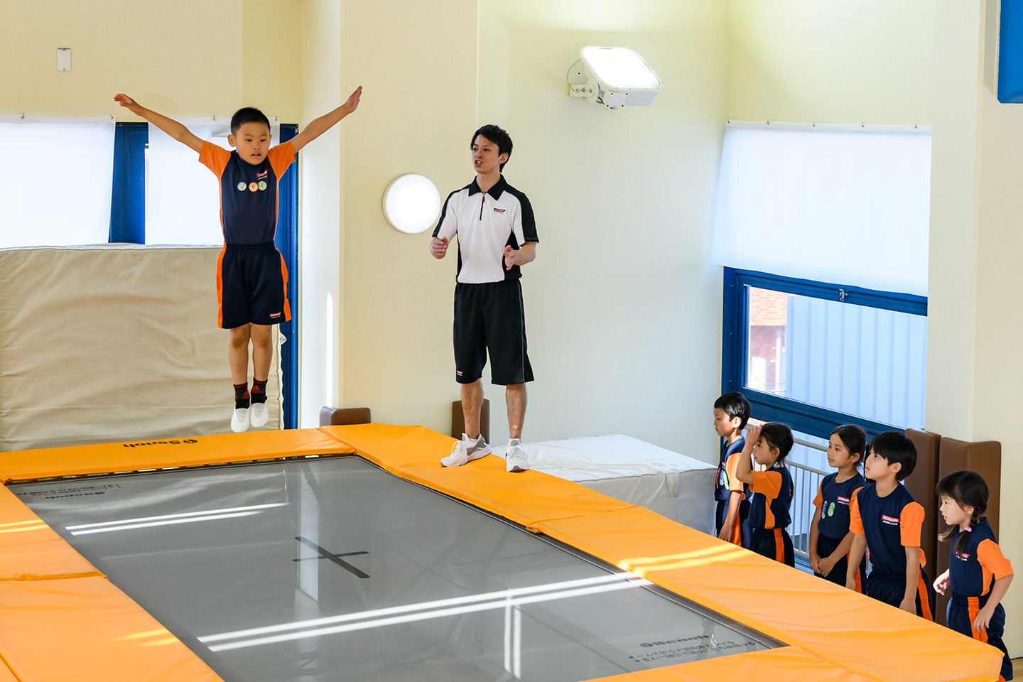 コナミスポーツクラブ トランポリンスクールの特徴 トランポリン スクールは ほめる型指導 や 段階別指導 を組み合わせることで お子さまが効果的かつ安全にトランポリンの技を習得できるとともに 様々なスポーツに役立つ空中感覚を培うことが